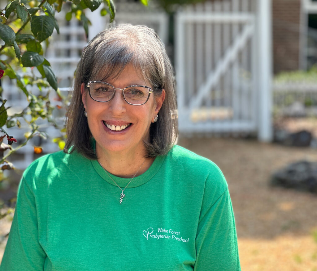 Photo of a mature, smiling woman wearing a WFPC Preschool T-shirt