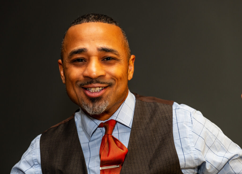 Photo of a smiling Gen X man wearing a tie and vest