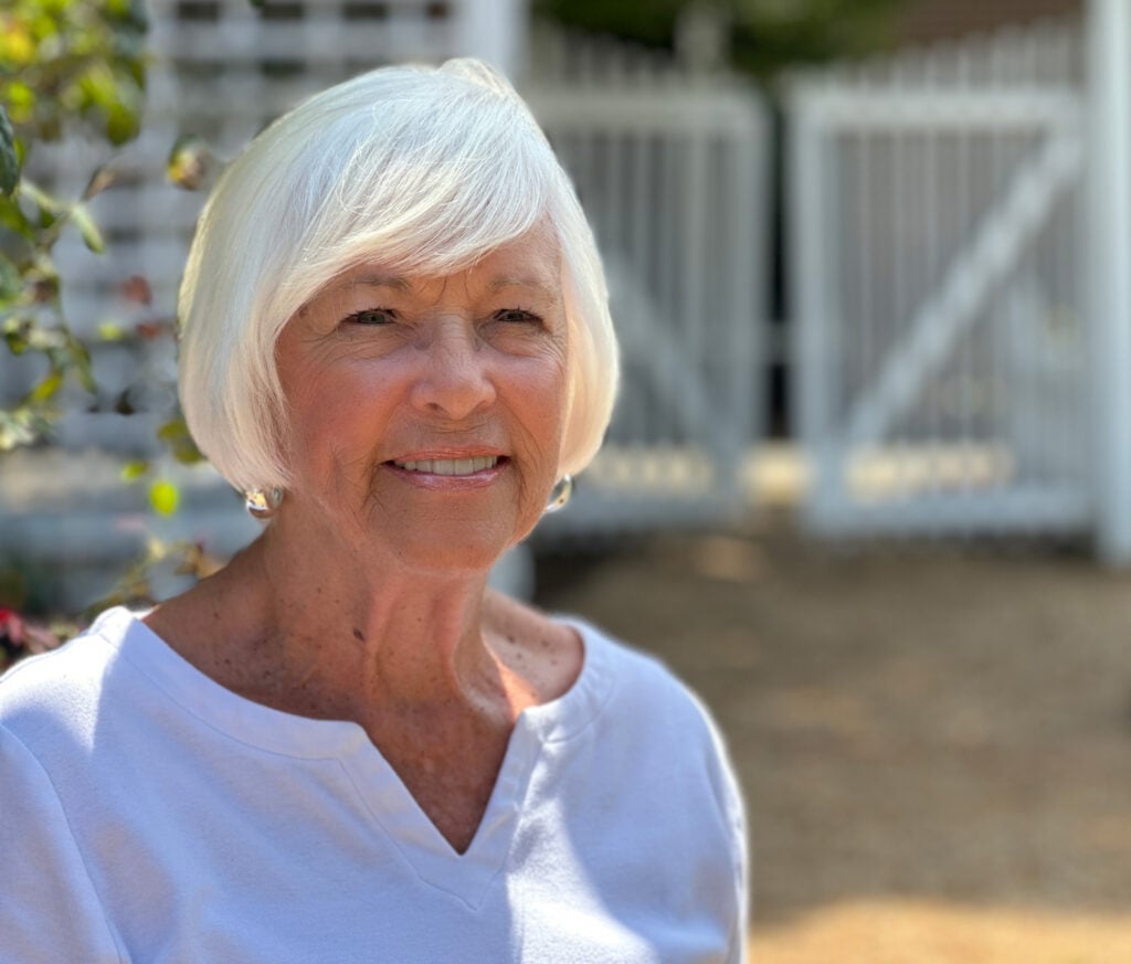 Photo of a mature, smiling woman wearing a white shirt